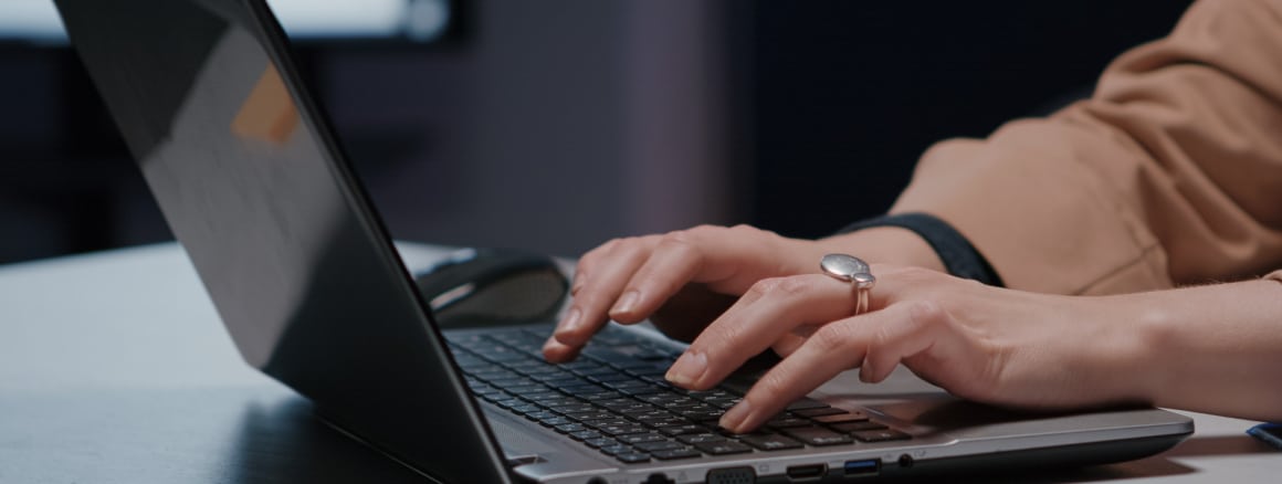 Close-up typing on laptop